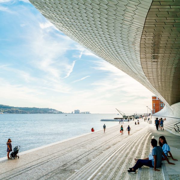 A photograph of students sitting by a harbour