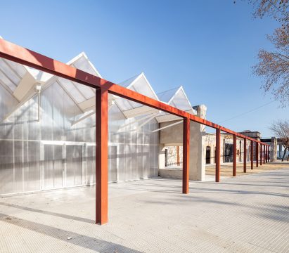 Photo of a glass structure with red steel