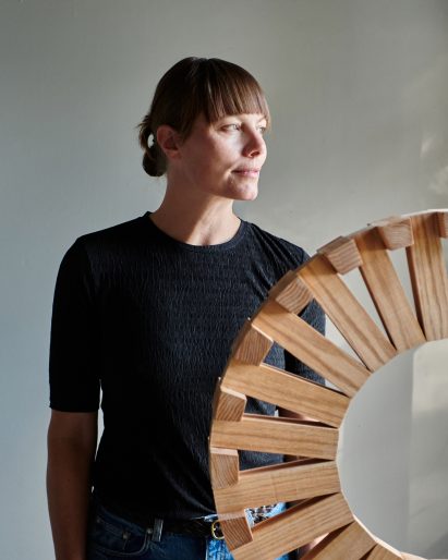 Red Oak Circuit, a wooden sculptural form in a gallery next to its designer