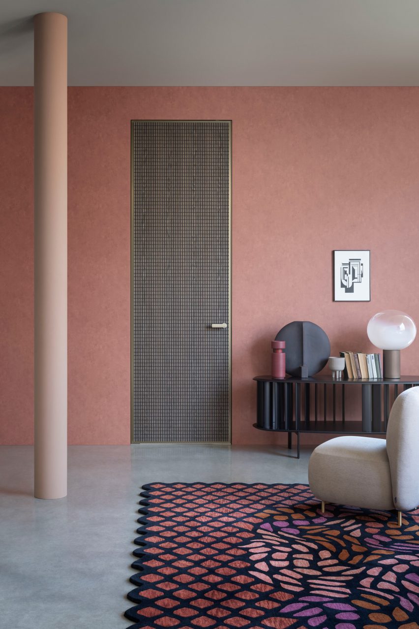 Wooden door with bronze outline in a pink-painted room