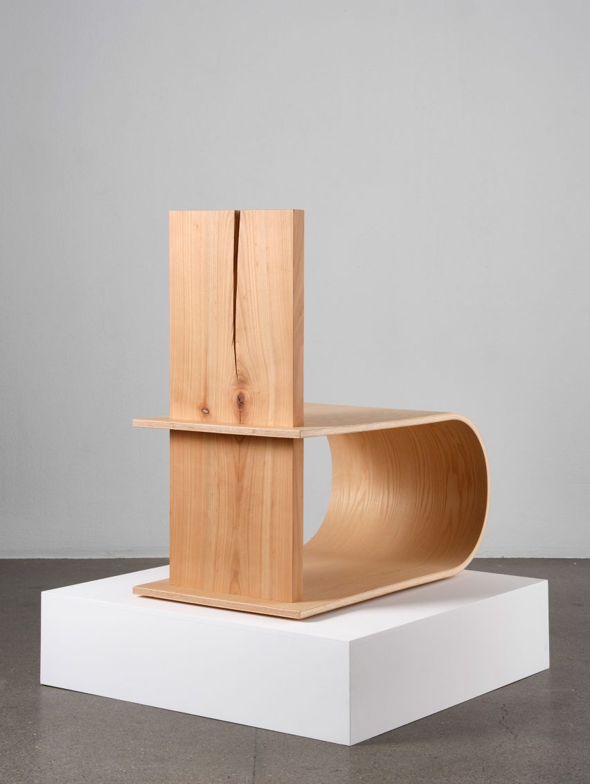 Photograph showing wooden chair on white plinth