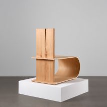 Photograph showing wooden chair on white plinth