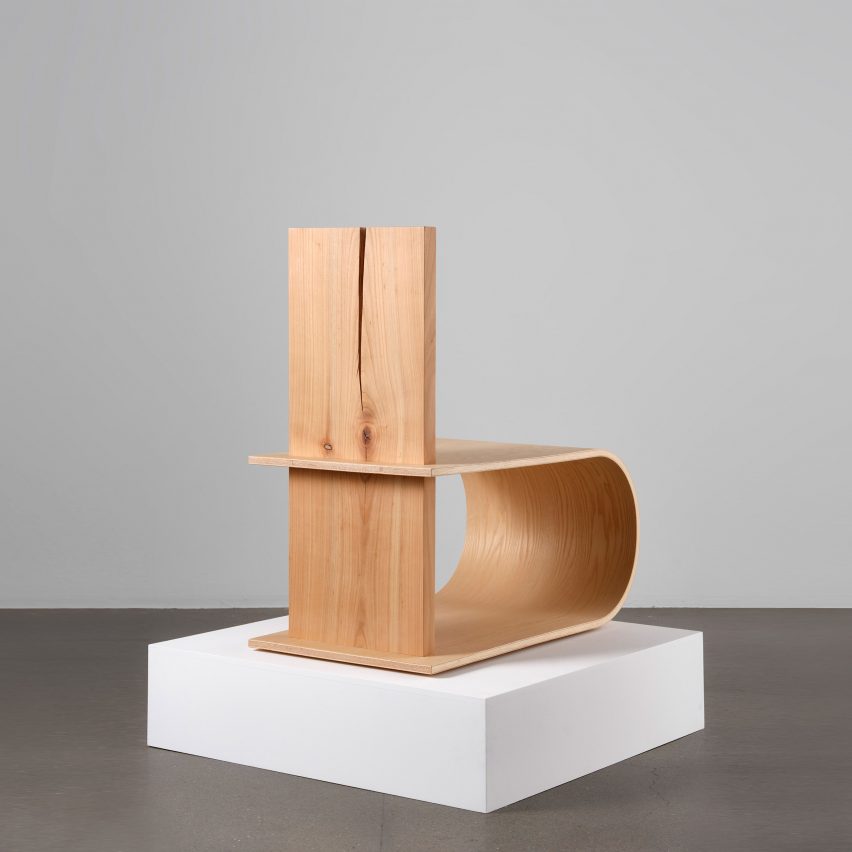 Photograph showing wooden chair on white plinth