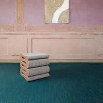 Bolon teal woven flooring in a pink room with a sculptural stool