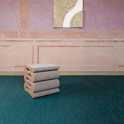 Bolon teal woven flooring in a pink room with a sculptural stool