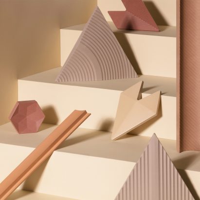Triangle, rectangle, hexagon and geometric Cavaril tiles in sandy and clay-toned colours placed on yellow steps