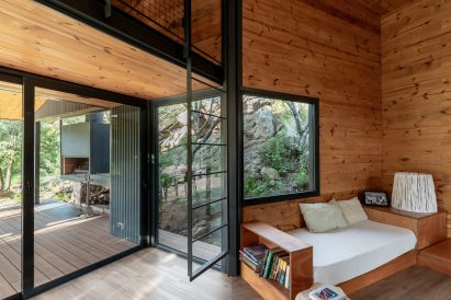 Futons in living area of Argentinian house with timber walls
