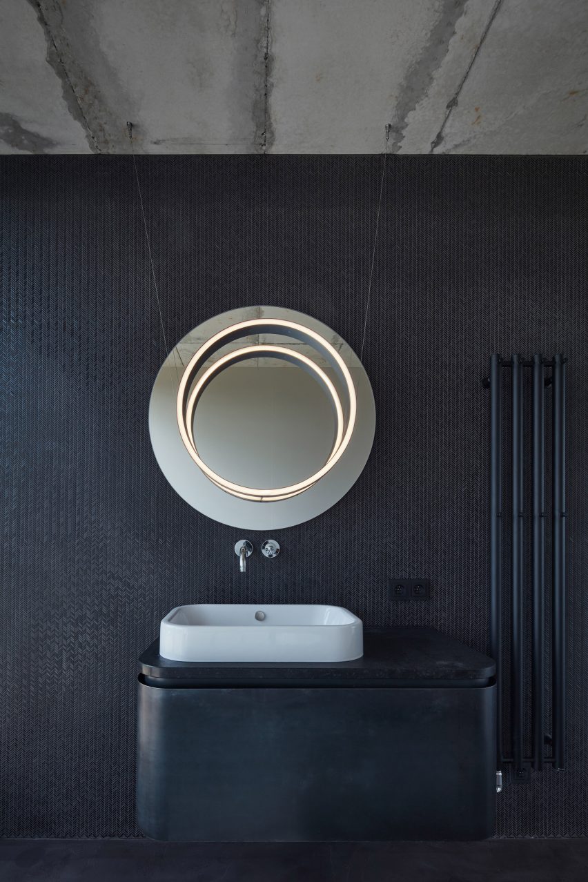 Photograph showing sink and vanity mirror in concrete bathroom