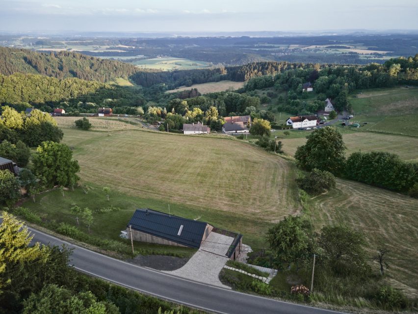 Photograph showing single-level gabled house looking over countryside