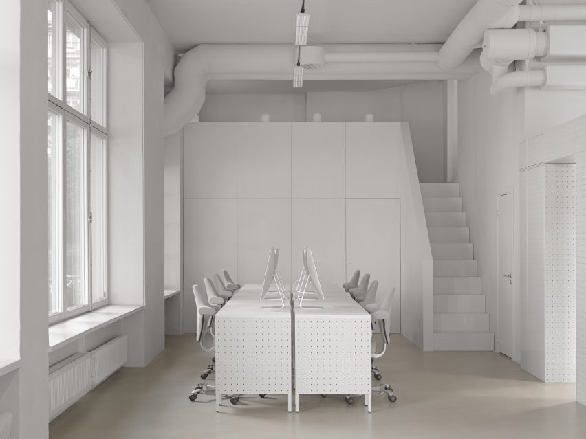 White desks and chairs in white-walled room