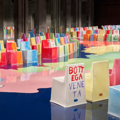 Resin covered chairs are lined around a runway at Bottega Veneta