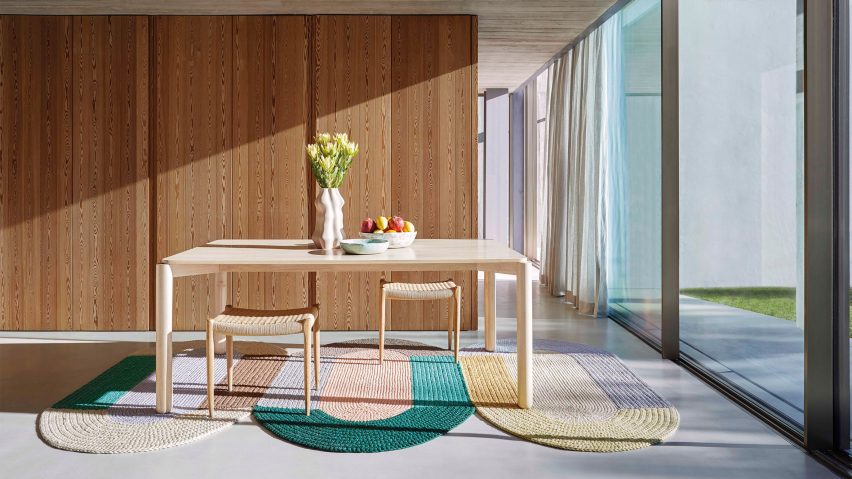 Three crochet rugs by Gan in a dining room under a wooden table and chairs