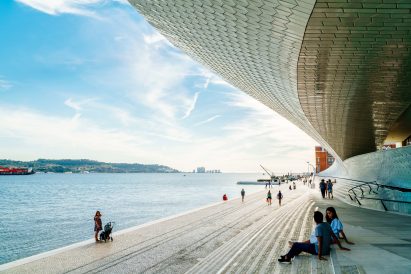 A photograph of students sitting by a harbour