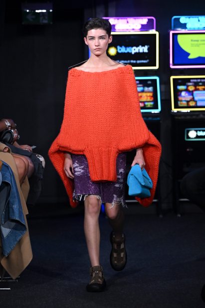 An orange jumper was worn upside down at JW Anderson Spring Summer 2023