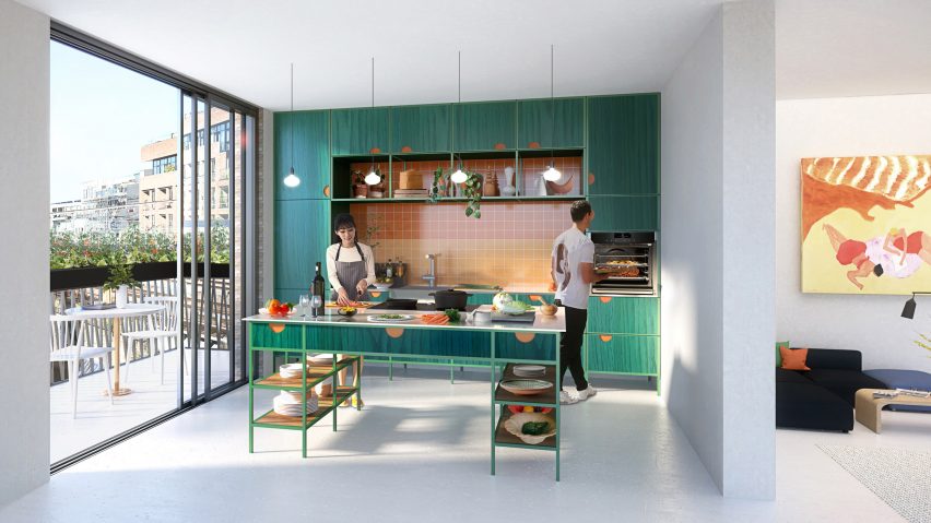 Man using Neff Slide & Hide oven while woman cuts vegetables in small green kitchen