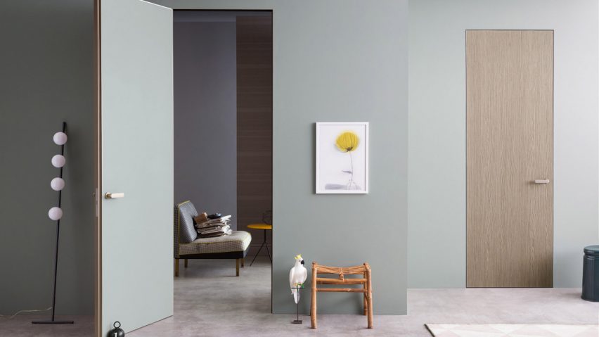 Two Lualdi doors in a teal-painted hallway, one open and painted teal and the other closed with oak veneer finish