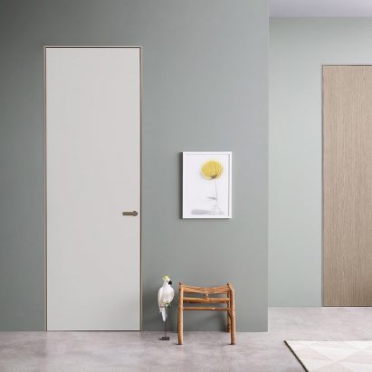 Two Lualdi doors in a teal-painted hallway, one door is white and the other is finished in oak
