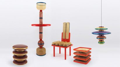 Photograph of furniture including chair, lamps, stool and table on white backdrop