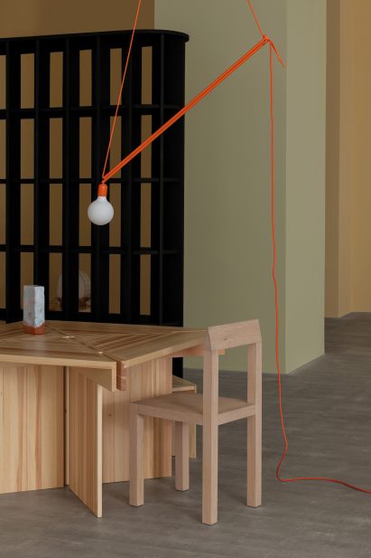 A wooden table with a matching chair and orange lamp