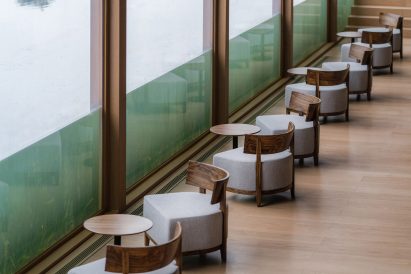Image of a seating area beside a glazed wall that is part submerged at Xinglong Lake Citic Bookstore