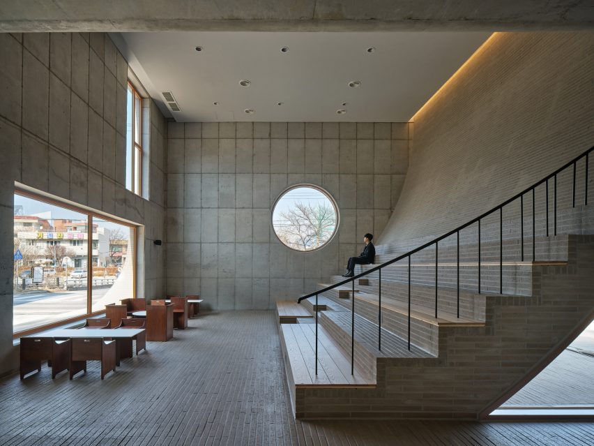 Cafe interior with polished concrete walls and sloping wall with concrete brick steps