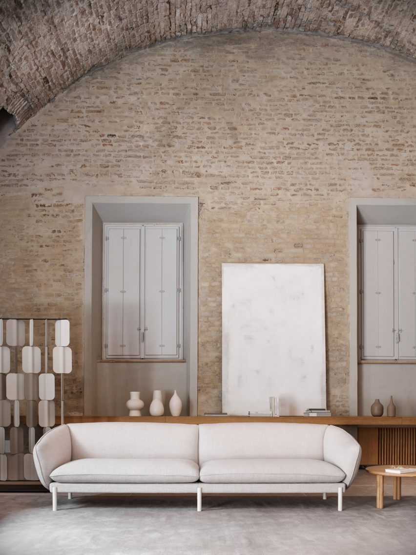 White Not Sofa by True Design in a living space with a brick wall