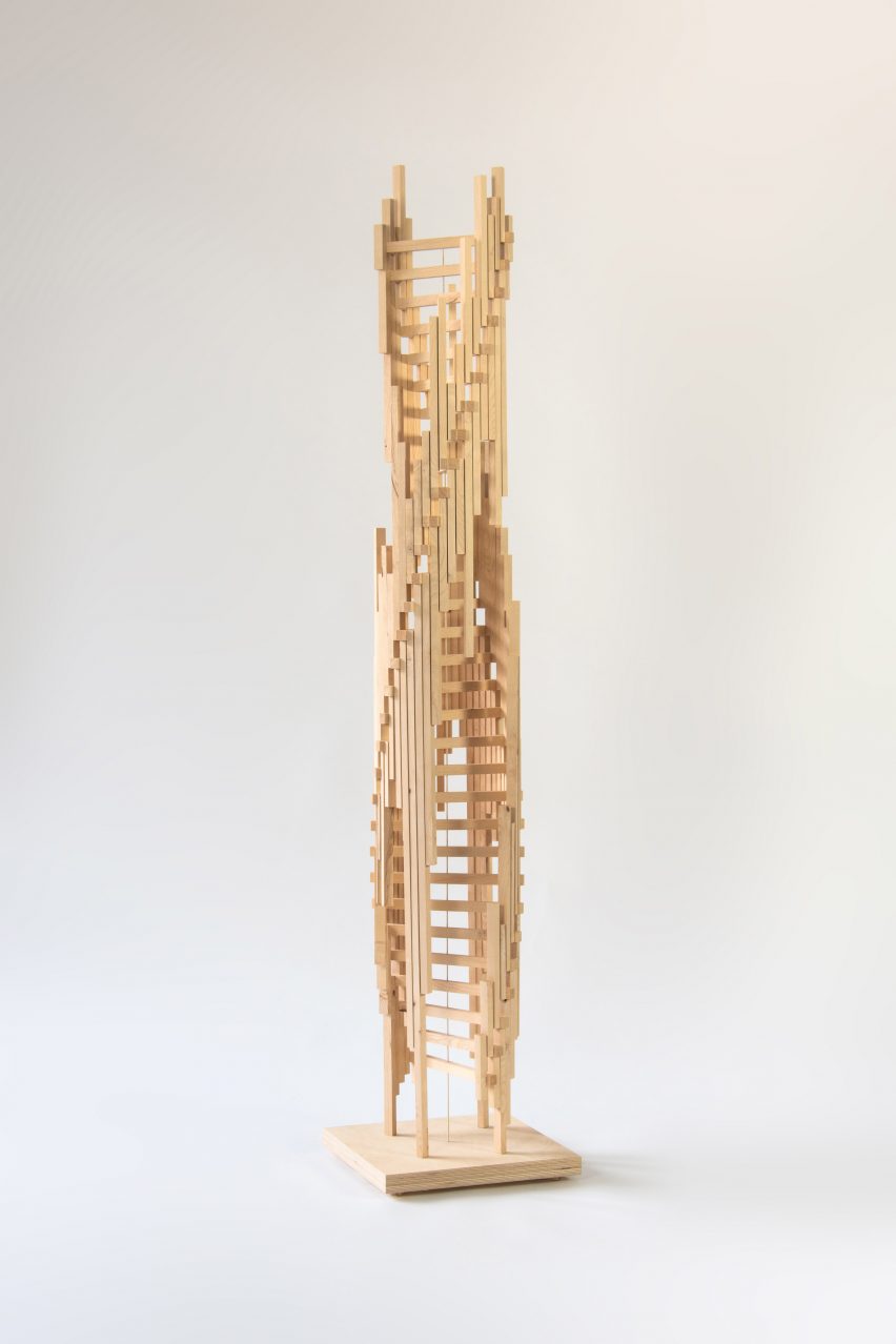 Photograph showing complex vertical sculpture on white backdrop