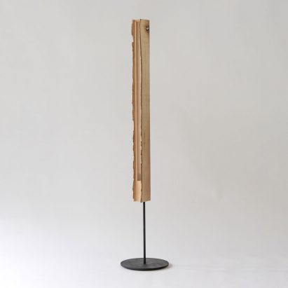 Photograph showing standing lamp with raw edge wood