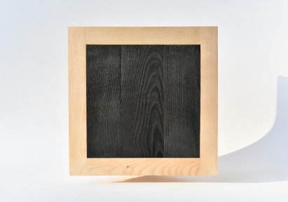 Photograph showing blackened wood square with ash wood frame surround