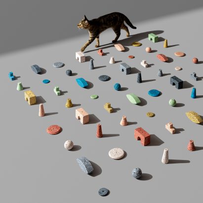 A cat walking between colourful tiles