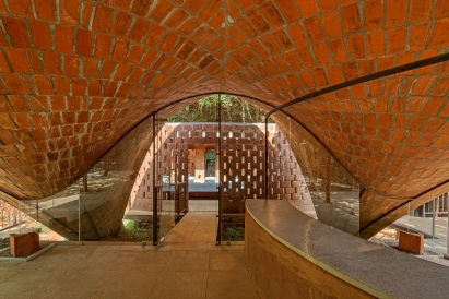 Underside of vaulted tile ceiling in restaurant by Play Architecture with glass door leading to decking
