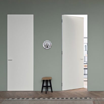 Photograph showing white doors in sage green wall