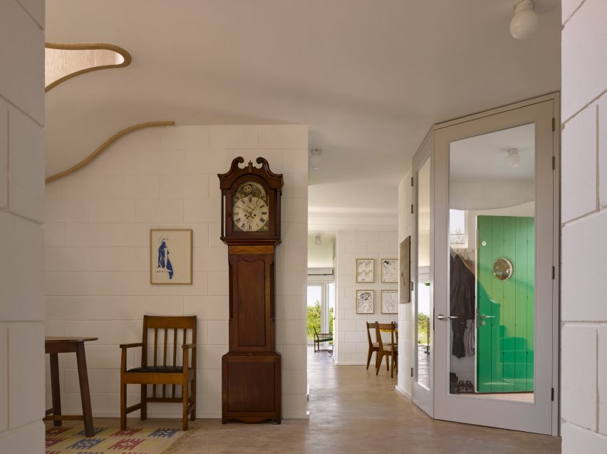 Hallway with grandfather clock in Red House by David Kohn Architects