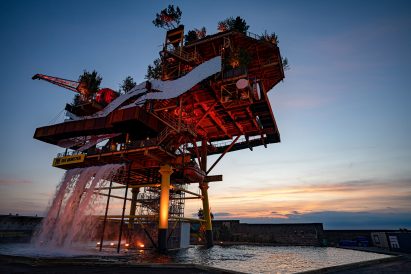 A large gas rig with plants and trees 