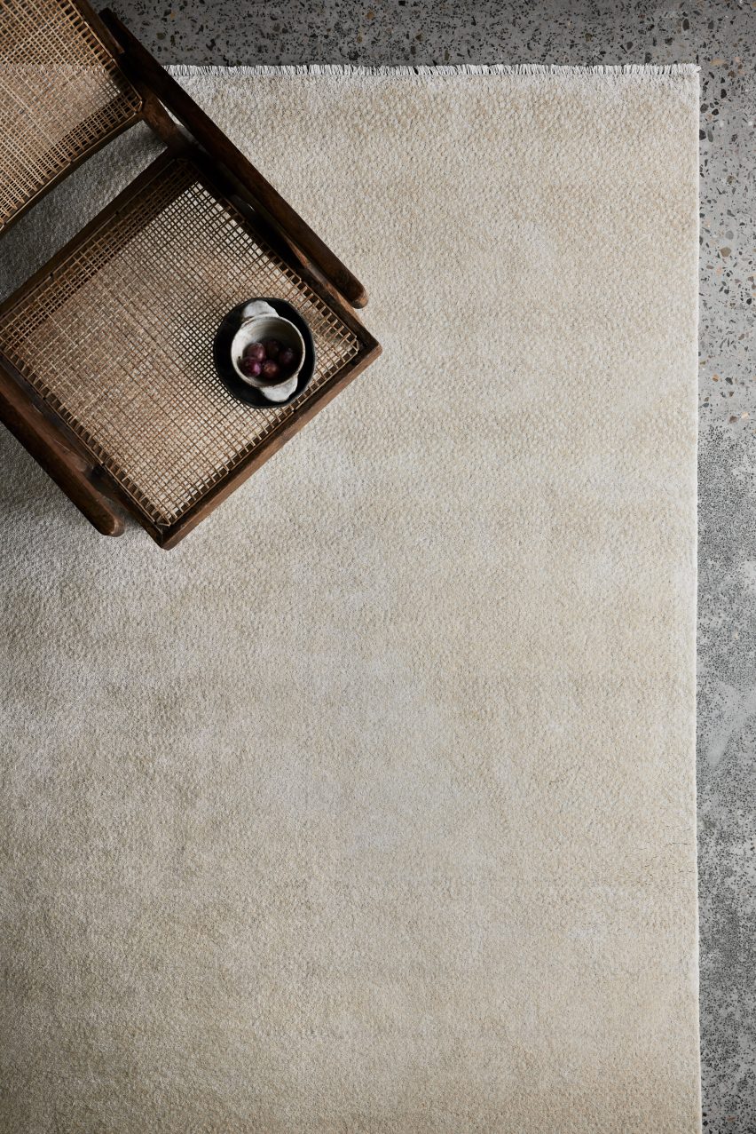 Photograph showing cool-toned living room with neutral-coloured rug