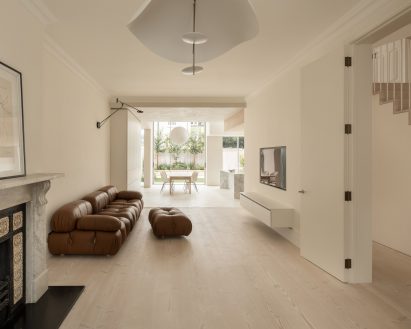 White-walled living room connected to open-plan kitchen and diner