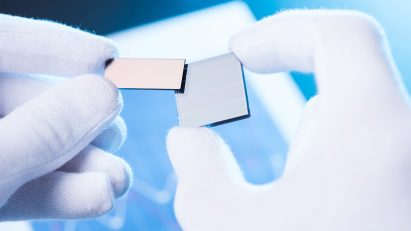 Gloved hands holding small solar cells