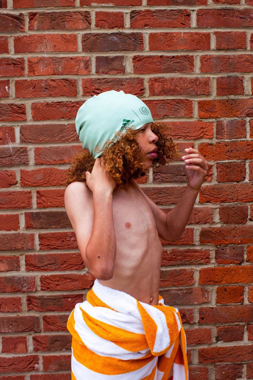 A boy wearing a swimming cap and shorts