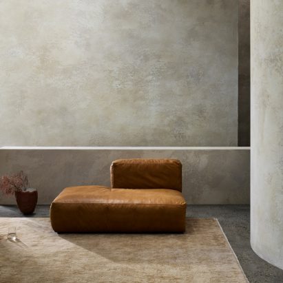 Photograph showing warm neutral rug and orange leather seat