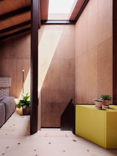 Wooden staircase with skylight and yellow storage unit