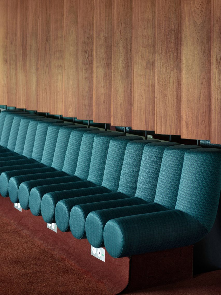 Photograph showing airport departure lounge with green bench seats