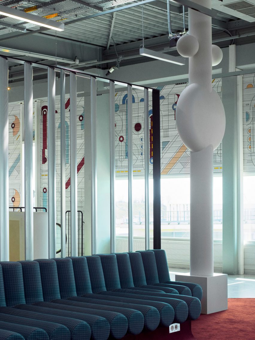 Photograph showing airport departure lounge with green bench seats and large tree-like rounded white sculptures