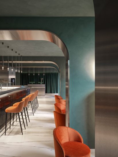 Green walls and orange chairs in hotel restaurant
