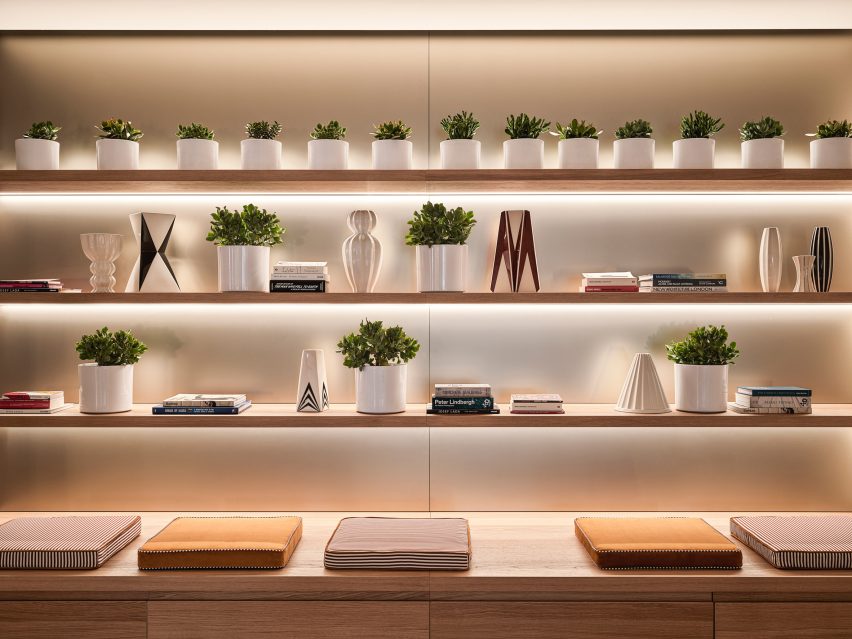 A wall with small potted plants and a bench