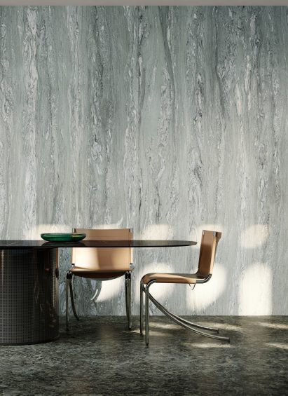 Photograph showing dining chairs and table with marble patterned wall behind