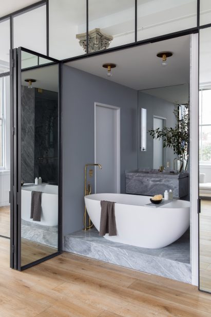 Freestanding bath tub behind bi-fold doors