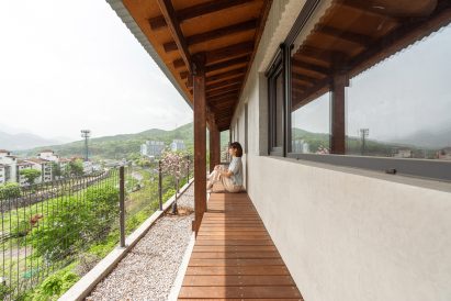 Image of a person sat on the deck surrounding Bugok Friday House