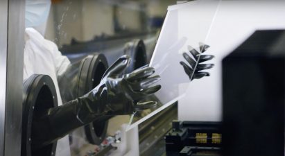 Gloved hands holding a transparent solar panel
