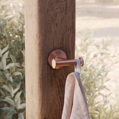 Brass towel hook on a wooden column outside