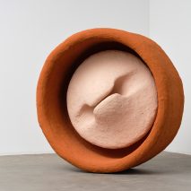 Photograph of a large-scale circular sculpture in pink and orange